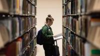 Student browsing library shelves